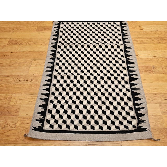 Add a touch of cultural heritage and visual intrigue to your space with this vintage Native American Navajo area rug,...