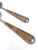 A refined set of handmade salad servers featuring polished stainless steel heads and handwoven rattan-wrapped handles....
