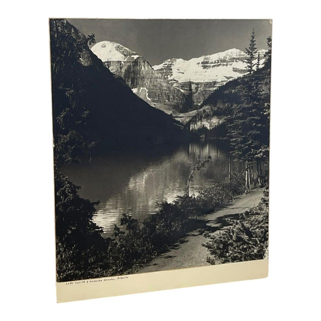 Vintage black and white landscape photograph depicting Lake Louise and the Victoria Glacier in Banff National Park,...
