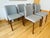 Walnut framed dining chairs upholstered in a light gray ducale wool from the Homstvedt & Takagi designed Contour...