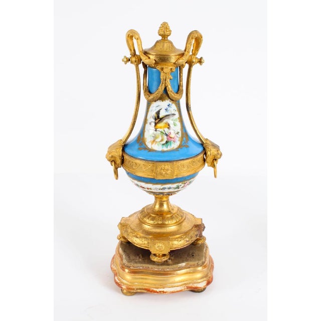 This is a beautiful antique pair of French Sevres style porcelain and ormolu mounted twin handled urns, in the Louis XV...