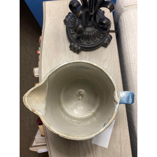 Produced by the short-lived North Star Stoneware Company of Red Wing, Minnesota (1892-1897), this white pitcher has a blue...