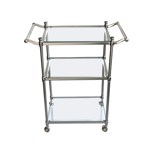 Ideal for a smaller space, of polished and brushed chrome construction supporting three beveled glass shelves all joined...