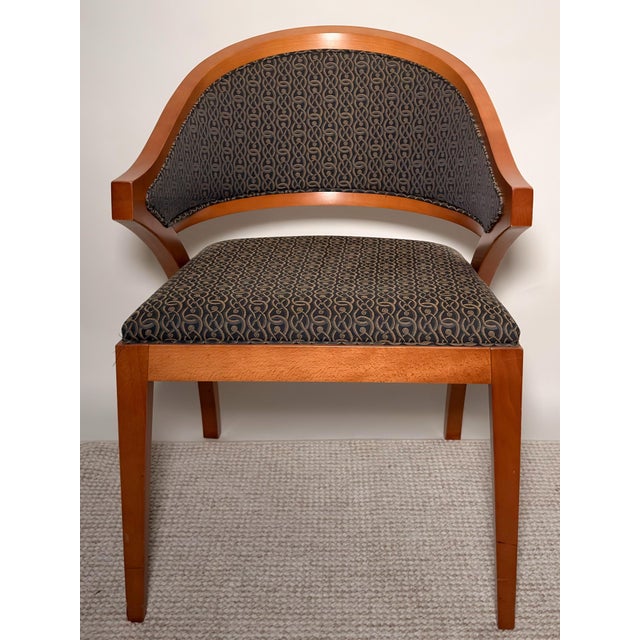 A sculptural accent chair by Gunlocke featuring a gracefully curved wood frame and upholstered seat and back. The design...