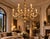 An eight-light chandelier featuring a carved wooden frame with a silver-gilt finish, adorned with acanthus leaf motifs and...