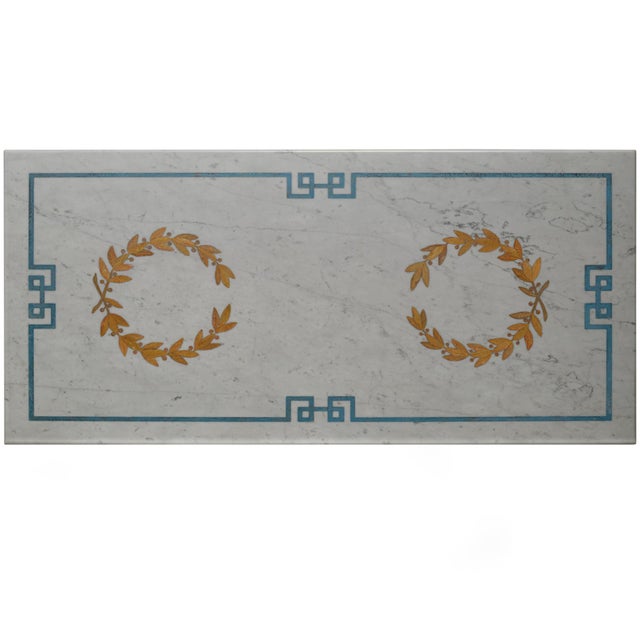 Coffee table made with the decorative technique of scagliola inlay on a white Carrara marble top, which rests on a wrought...