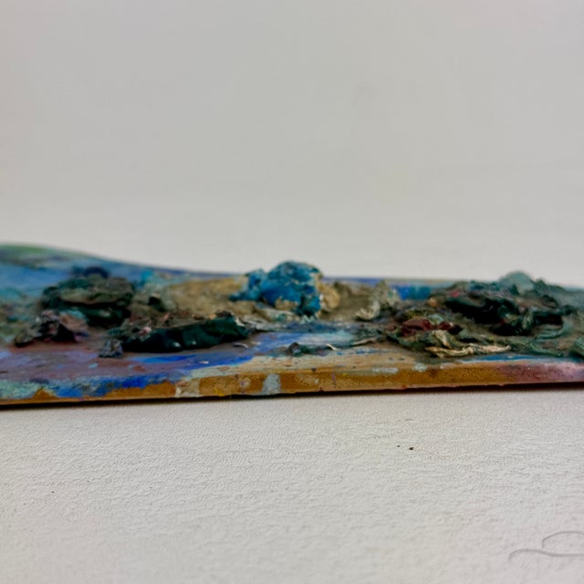 A lovely, unique, small artist's painting palette with original dried oil paint, that's heavy on the blues. The shape...