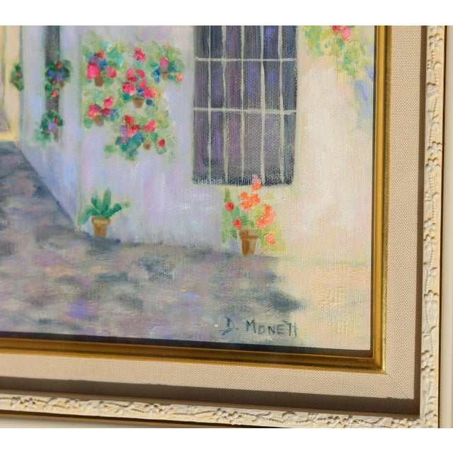 Hanging off of the white stucco facade, pots and baskets of lush flowers frame the balconies and stone streets of the...