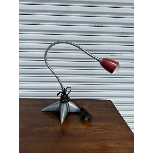 The lamp's shade boasts a rich red finish, adding a touch of color and sophistication, which enhances both workspaces and...