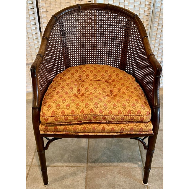 Set of four mid-century faux bamboo barrel chairs featuring cane backs and elegant wrap-around sides. Each chair showcases...