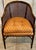 Set of four mid-century faux bamboo barrel chairs featuring cane backs and elegant wrap-around sides. Each chair showcases...
