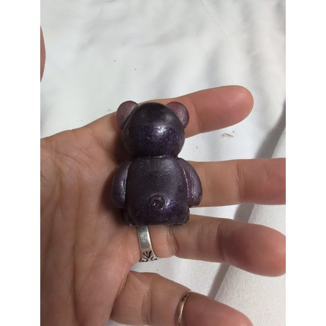 Charming purple glass bear figurine with a glossy finish. • Crafted from high-quality glass • Compact and decorative...