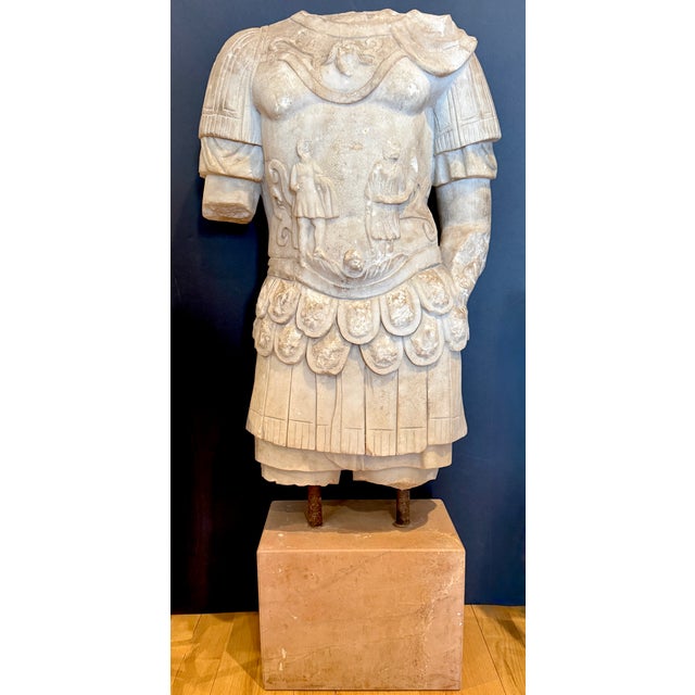 This life-size carved marble torso depicts a Roman soldier wearing an elaborately ornamented cuirass and military skirt,...