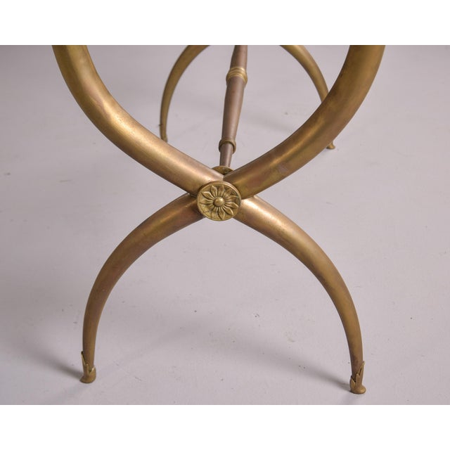 Found in Italy, this tall glass and brass-clad bar cabinet dates from the 1980s. Brass curule base has decorative details...