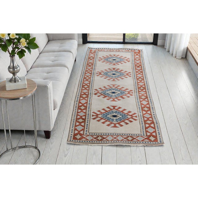 This is a vintage Turkish Oushak rug from the Mid 20th Century. The piece was hand-knotted.