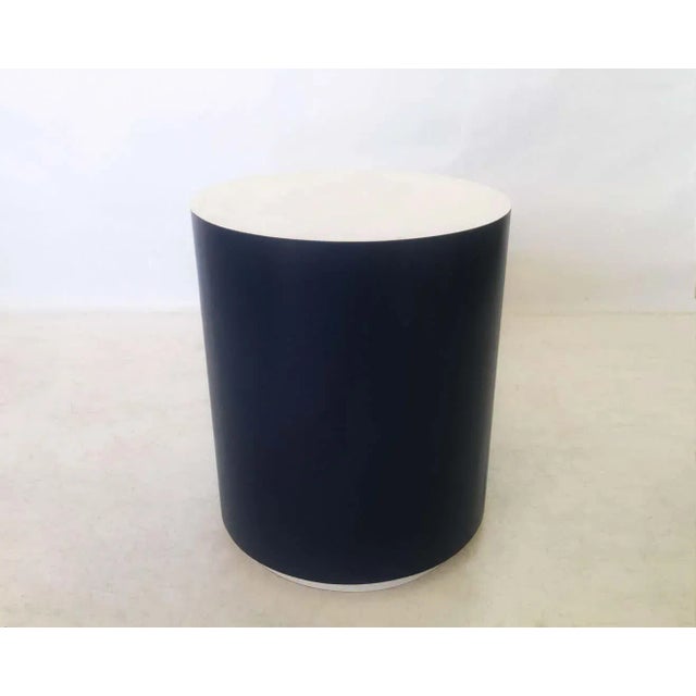 An eye-catching cylinder shaped side or drinks table. Table is freshly featuring a navy blue exterior with contrasting...