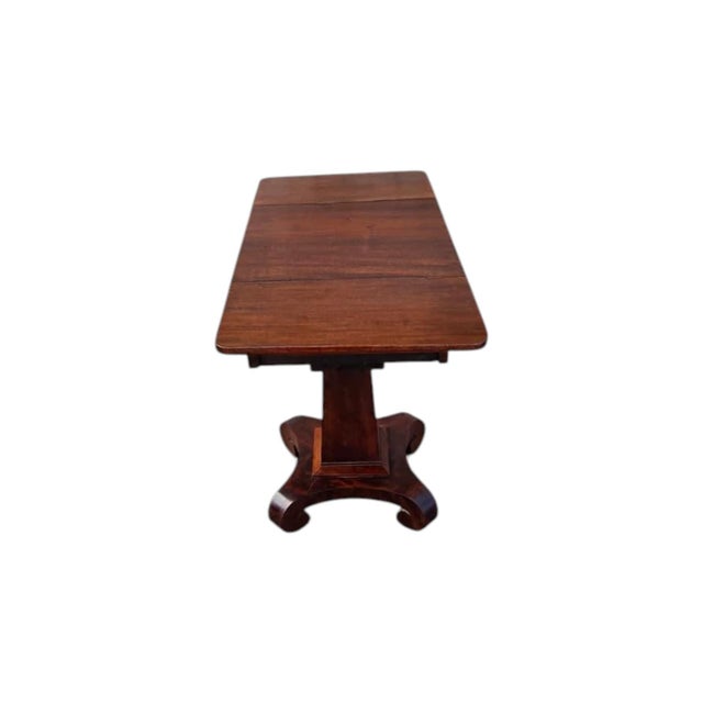 The 1840 American mahogany Empire drop leaf side table is an antique piece from the Empire brand, featuring intricate...