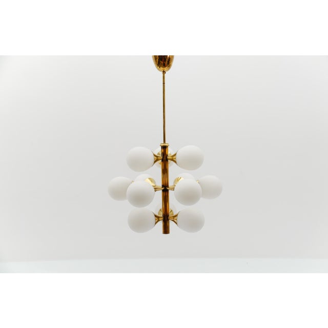 Beautiful golden sputnik chandelier from the 1960s. the opal glass lampshades spread a cozy light. the lamp has a very...