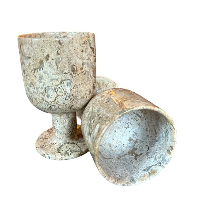 Set of four stone goblets made from a beautifully textured and polished natural stone, likely fossilized marble. Each...