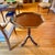 The tabletop has an eight-sided geometry mahogany top bounded by a raised, cherrywood gallery with gold trim. The...