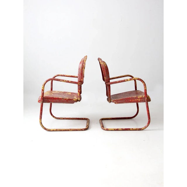 This is a pair of mid 20th century vintage patio chairs. The art deco steel metal garden chairs have bouncer frames with...
