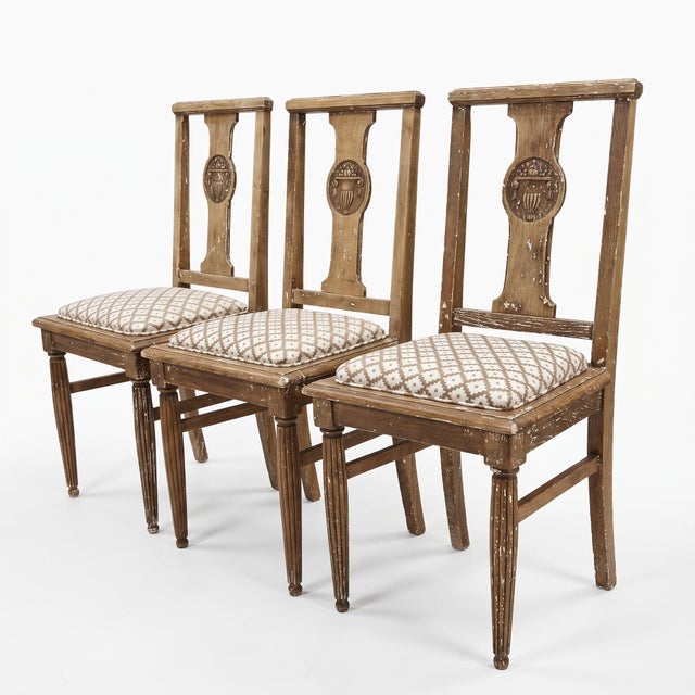 A set of three Neoclassical Revival dining chairs, Continental European, early twentieth century. Each back is built...