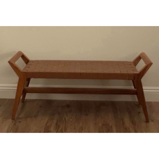 Beautiful Cove-style bench attributed to Union Home, featuring a recycled teak frame with a tightly handwoven brown...