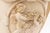 A large-scale Hydrastone chalkware urn in warm taupe, with twin handles and relief-molded cherub figures in the Greco-...