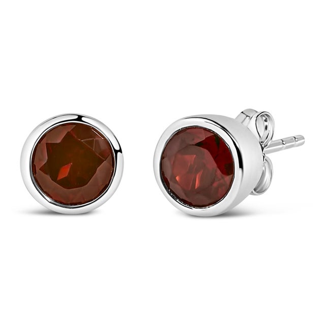 Immerse yourself in the vibrant allure of these exquisite stud earrings, each featuring a lab-created, color-treated red...