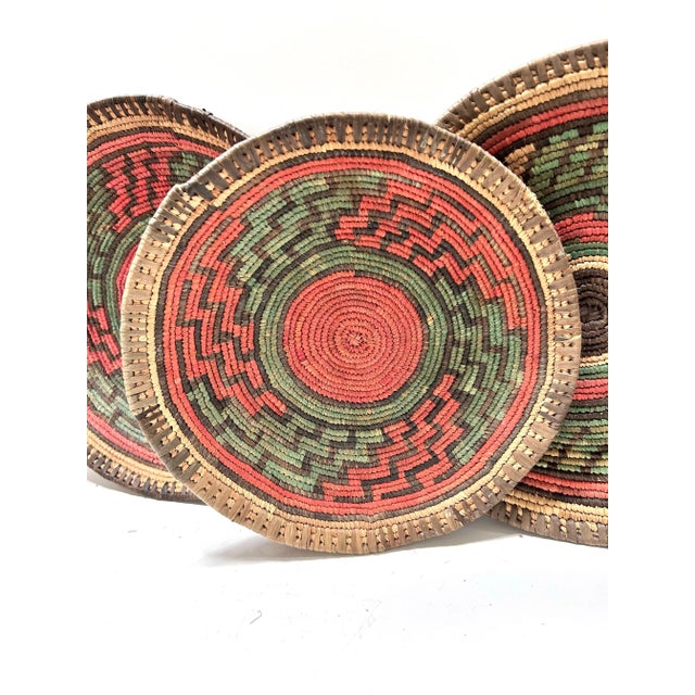 A beautiful set of three early 20th century African coiled basket bowls, likely from Uganda. These artisan-made baskets...