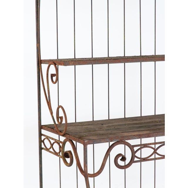 This circa 1930 French wrought iron étagère has a graceful, architectural presence defined by ascending shelves, curved...