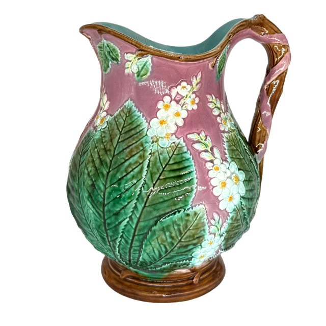 A George Jones Majolica Baluster-Form Pitcher, the body with relief-molded chestnut leaves and blossoms on a deep pink-...