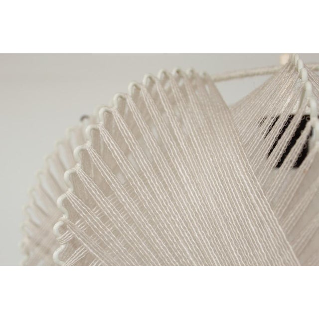 Vintage design cotton yarn fixed to transparent plastic tape, the tape wrapped around the white painted metal wire body....