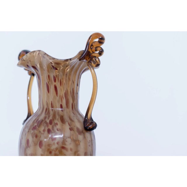 Wonderful vintage Murano glass vase designed by Fratelli Toso in the 1920s. The blown glass is amber-coloured with dark...