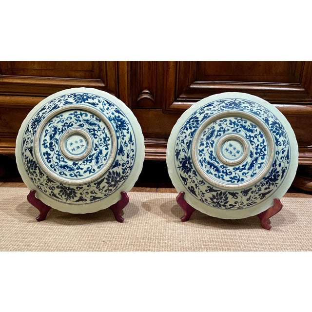 A striking pair of oversized blue and white Chinese porcelain charger plates featuring traditional dragon and phoenix...