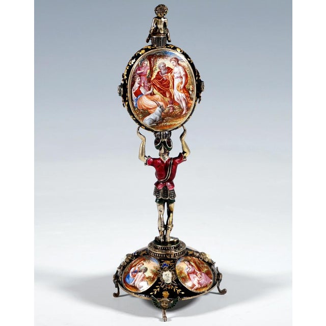 Artfully decorated silver clock by a Viennese master: Silver figure of a Roman foot soldier or squire in a short tunic...