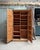 This antique notary's cabinet, crafted from solid oak, impresses with its elegant facade featuring numerous molded panels...