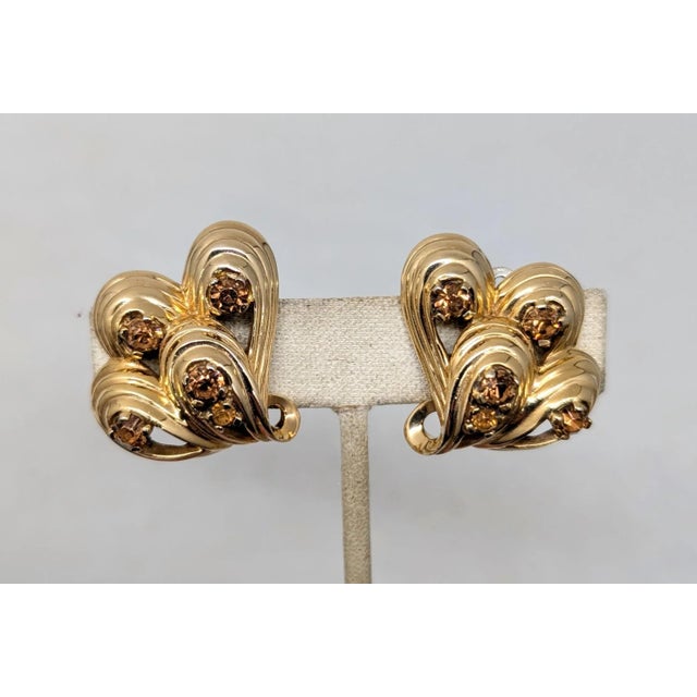 1960s goldtone loops with round prong set faux-topaz clip earrings. Marked "JOMAZ" on the clips. Measure: 1 3/16 inches...