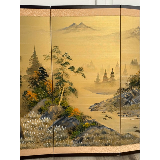 This vintage mid-century Japanese four-panel byōbu screen features a beautifully hand-painted landscape on a luminous...