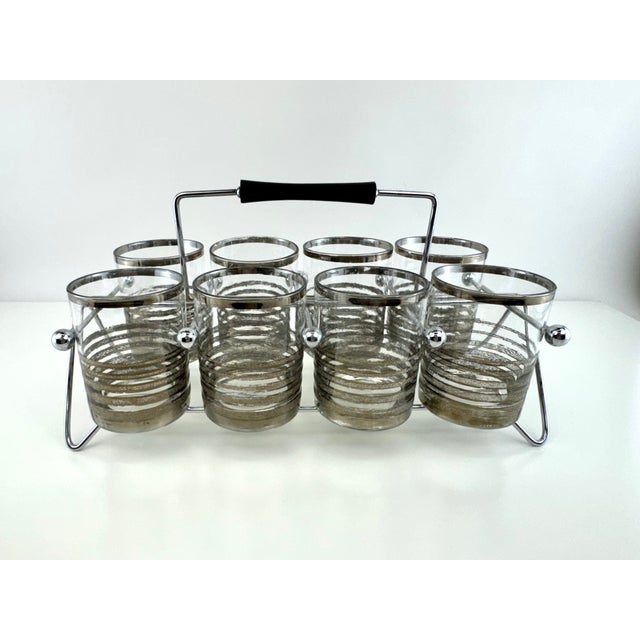 Stylish mid-century cocktail glass set featuring eight silver-rim tumblers with textured metallic band detailing housed in...