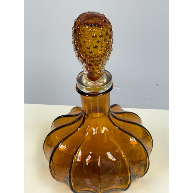 Design Plus Gallery presents the Amber Glass Decanter by Diamond Star. The molded glass body displays a sculptural, lobed...