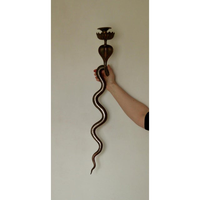 A remarkable pair of brass wall sconces in the Egyptian Revival style featuring a striking single cobra design. This...