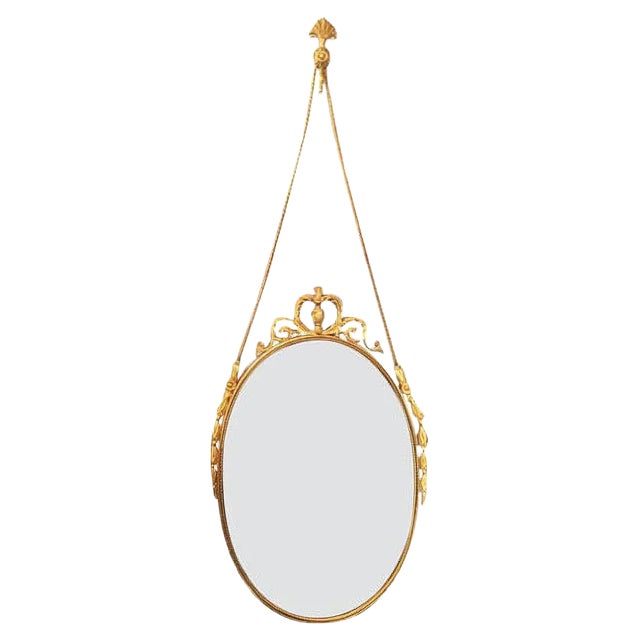 Vintage Oval Brass Mirror with Ornamental Decor For Sale