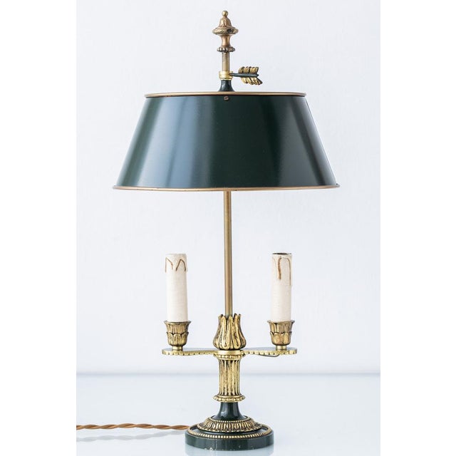 French Empire-style two-light bouillotte table lamp, France, 20th century. The gilt brass and bronze base is detailed with...