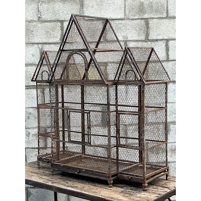 This monumental vintage wire birdhouse has the presence of a small architectural folly. Its iron framework forms a...