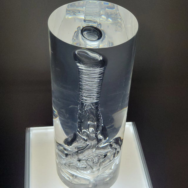 Mesmerizing mid-century cylinder shaped lucite sculpture. For display purposes, this sits on a lighted pedistal that is...