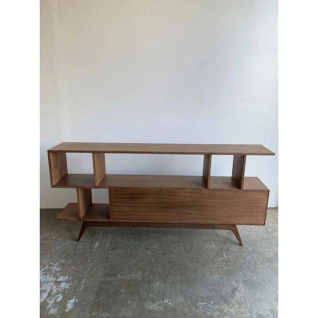 Minimal bookcase in walnut with both open dividers and closed sections. This item was fabricated for a home staging...