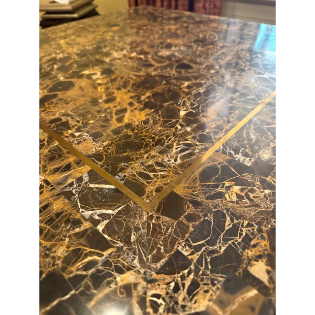 Square occasional table with a dark chocolate-brown Emperador-style marble top banded with inlaid solid brass, resting on...