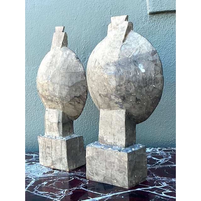 This striking pair of vintage tribal-inspired sculptures is a masterclass in global-chic artisanal design. Hand-carved...