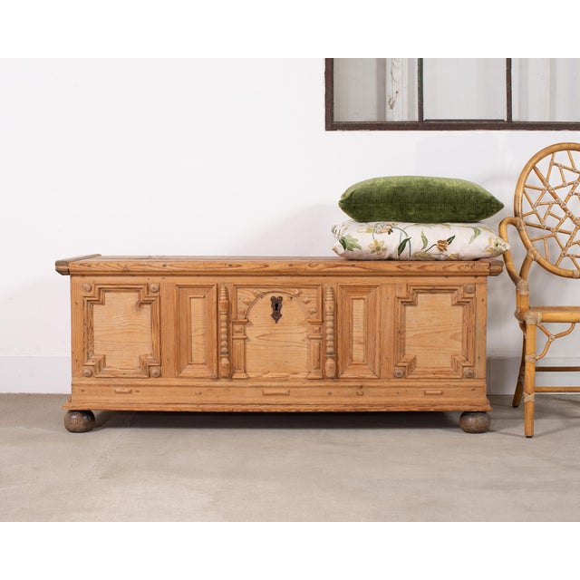 A handsome 18th century carved pine blanket chest in the Dutch baroque style with a paneled façade and storage space....